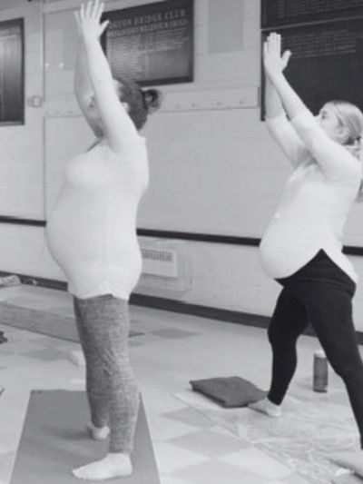 Two pregnant women doing gentle pregnancy yoga poses, promoting prenatal wellness and relaxation.