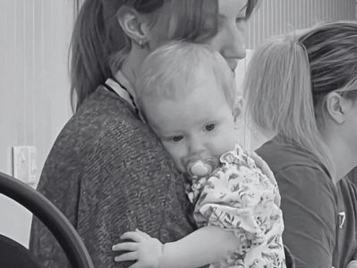 Mum cradling her baby during a calming Mum and Baby Yoga class in Peterborough.