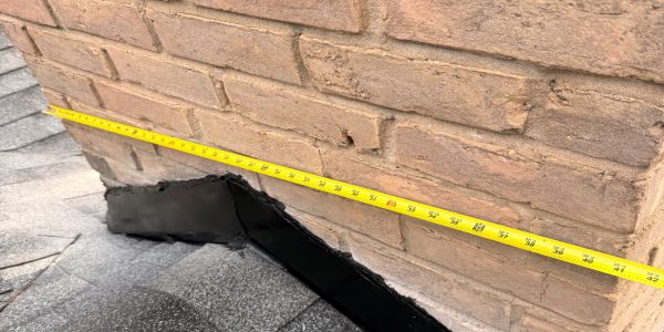 Measuring tape stretched along a brick wall on a roof.