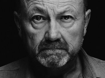 Retrato en blanco y negro de un hombre mayor serio.