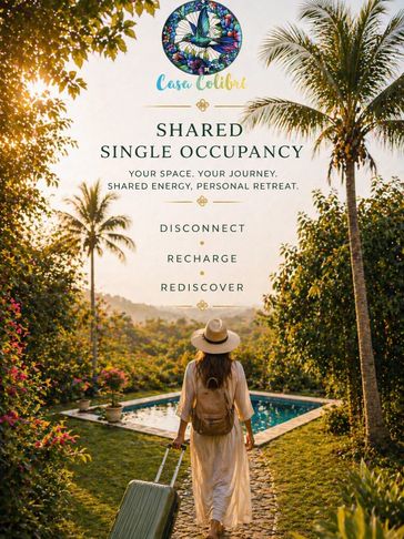 Woman with suitcase walking to a tropical retreat pool at sunset.