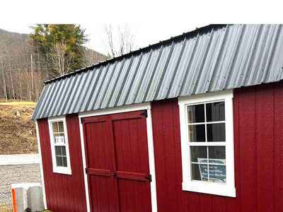 Red shed with double doors, two windows