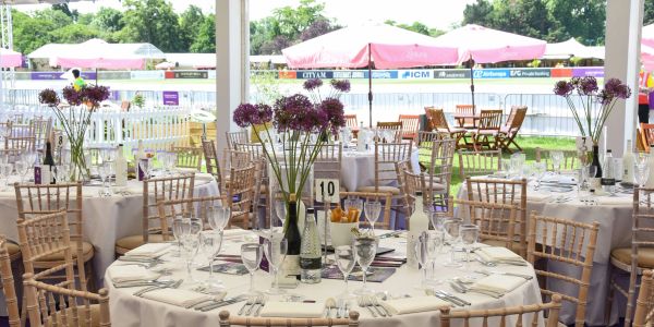 Outdoor dining setup with round tables and flowers.