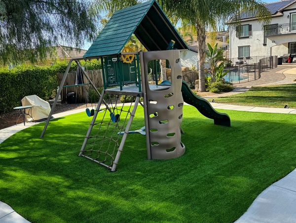 Children's playset with swing and slide in backyard.