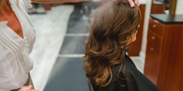 A woman getting her hair styled in a salon.