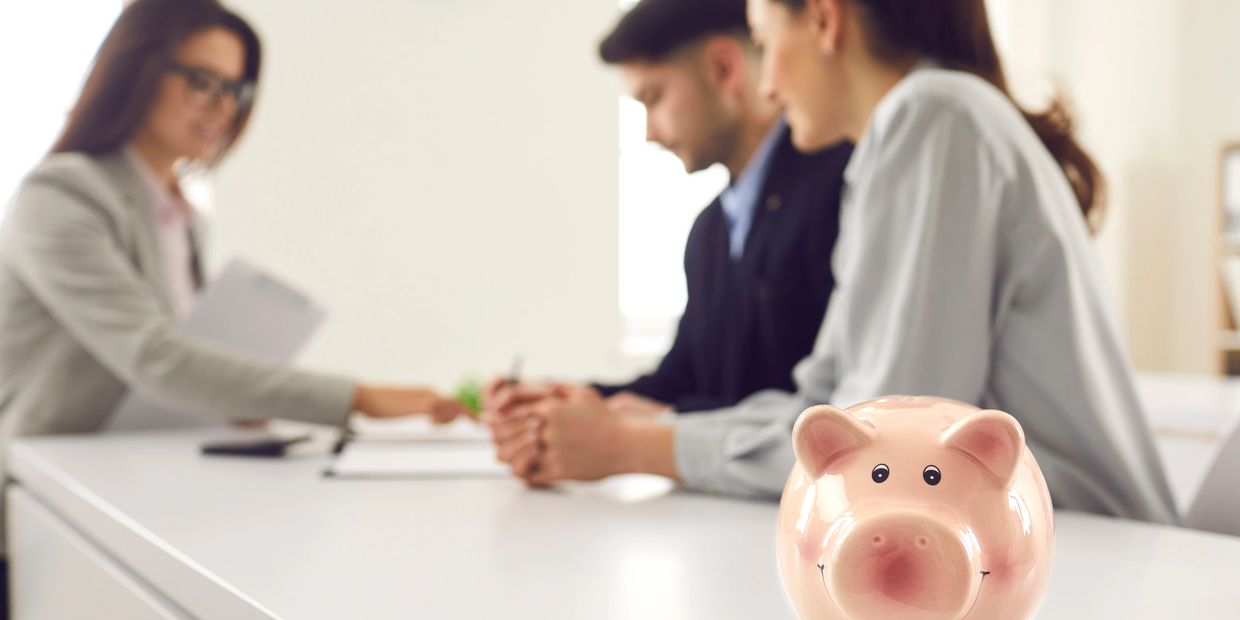 couple receiving consult from accountant expert with piggy bank
