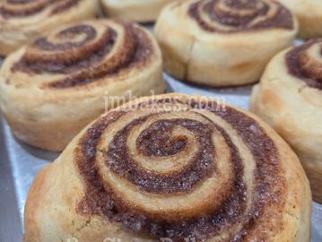 Freshly baked cinnamon rolls on a tray.