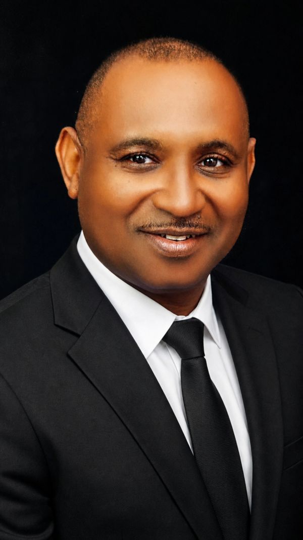 Man in black suit smiling at the camera.