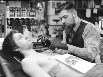 DAVE MUNCH/STAFF PHOTO
Jason Lynn tattoos Tyler Young at the House of Madness Tattoos
