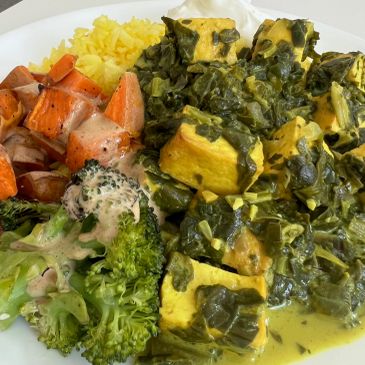 Plate with tofu spinach curry, broccoli, sweet potatoes, and yellow rice.
