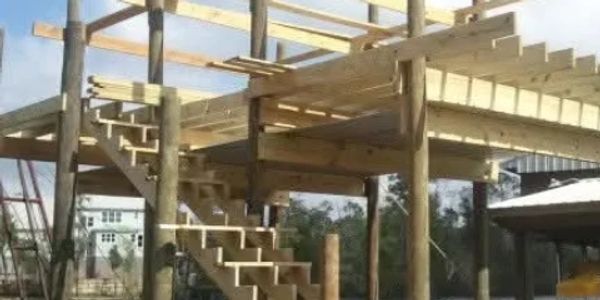 Wooden structure under construction with stairs and beams.