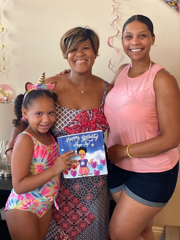 Teacher and parent embrace student who read a book during a summer camp