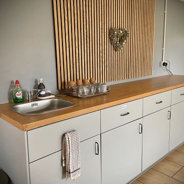 Minimalist kitchen counter with wooden top and sink.