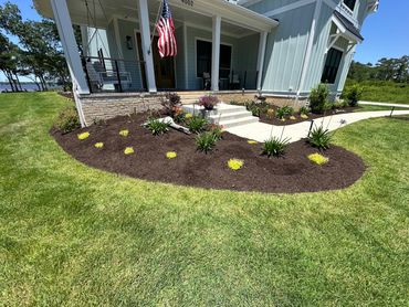 Residential landscape bed design with flowers and dark mulch Wilmington