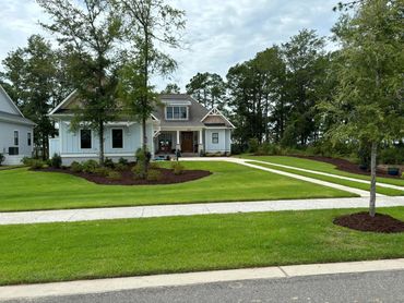 Professional grounds management team maintaining local subdivision lawn