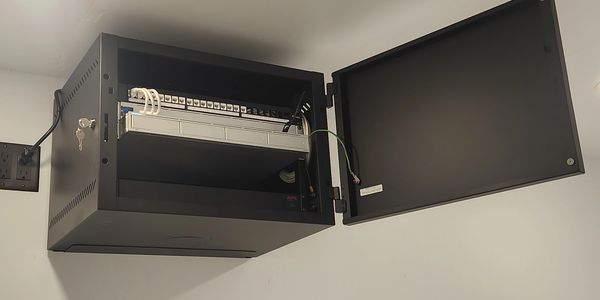 Wall Mounted Rack with a Cat6 patch panel, a switch, an NVR(network video recorder) and a PDU.