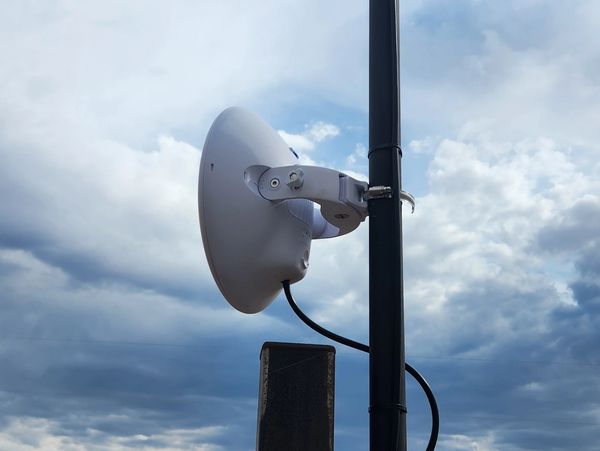 Wireless Radio mouinted on a mast at customers Gate. Allowing Cat6 to feed the network cameras.