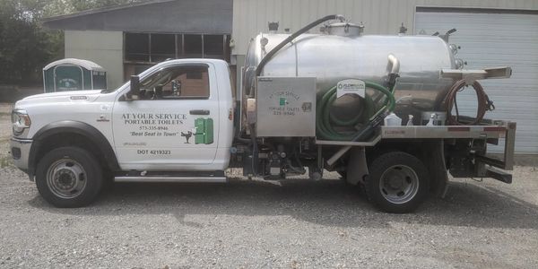 White septic service truck with company branding and equipment for portable toilet maintenance.