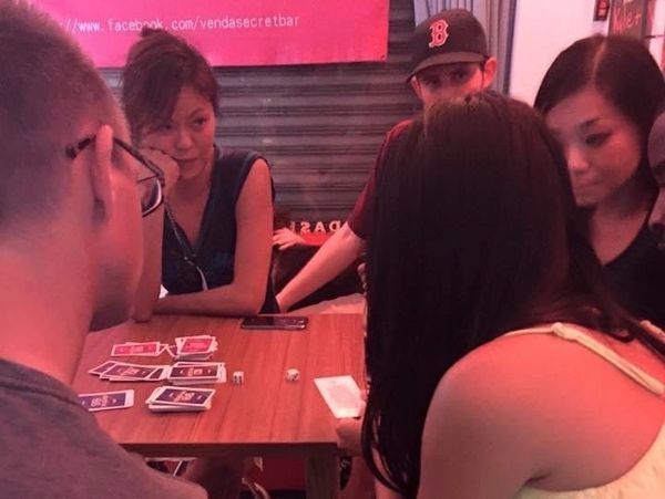 A group of people playing a card game and enjoying themselves