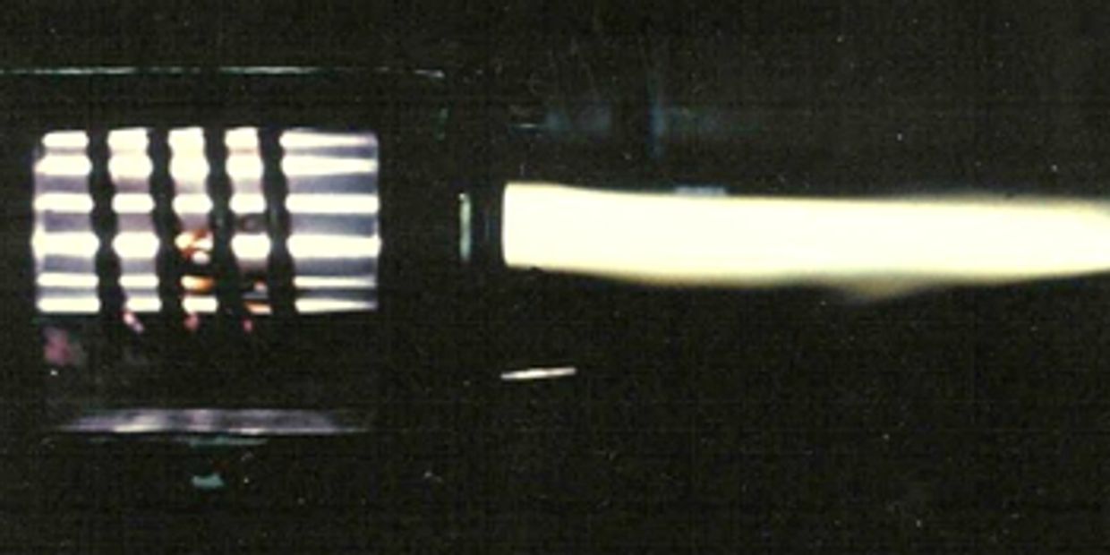 Bright plasma torch flame emitting intense light in a dark setting.