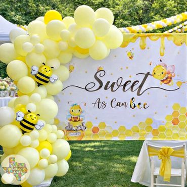 Yellow bee-themed party decoration with balloons and a "Sweet as can bee" banner.