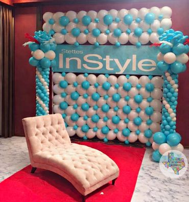 Elegant balloon backdrop with a plush chaise lounge on a red carpet.