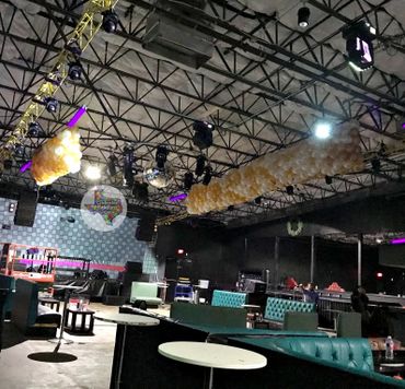 Interior of a dimly lit lounge with chandeliers and teal seating.