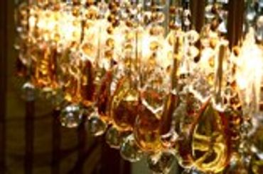 Close-up of numerous glass bottles with amber liquid, likely wine or spirits