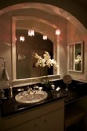 Modern bathroom with a large mirror, white sink, and floral decor