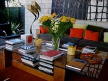 Wooden table with books and a vase of colorful flowers