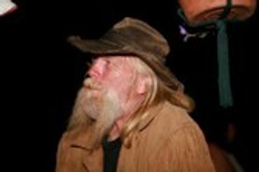 Older man with a long white beard and a hat