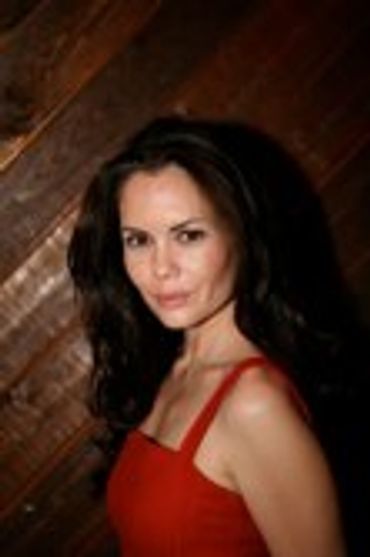 Woman with long dark hair, wearing a red top
