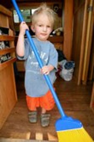 Child holding a blue stick indoors