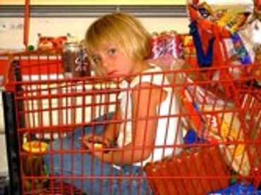 Child sitting inside a shopping cart.