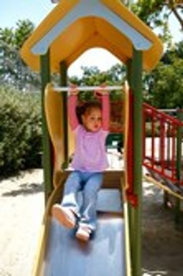 Child sitting on a colorful playground structure