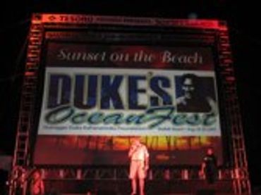 "DUKE'S OCEAN FEST" banner with a person below