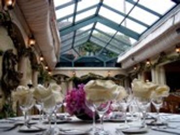 Event setup with tables and chairs under a skylight