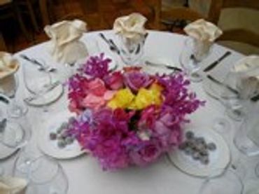 Table setting with a purple and pink floral centerpiece.