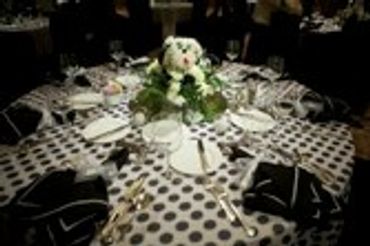 Elaborate table setting with white floral centerpiece.