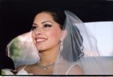 Bride smiling, wearing a veil.