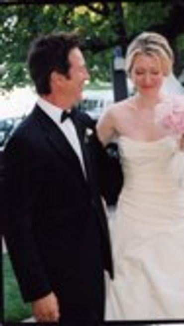 Groom in a tuxedo and bride in a white dress.