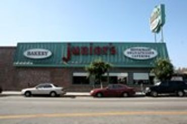 "Junior's" bakery building with cars parked outside.