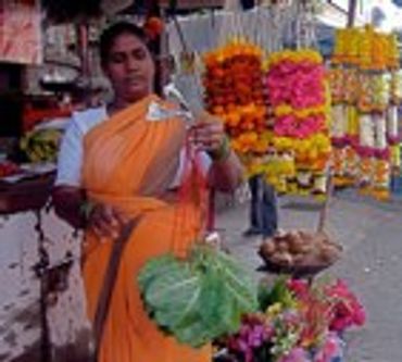 Woman selling flowers at a market.