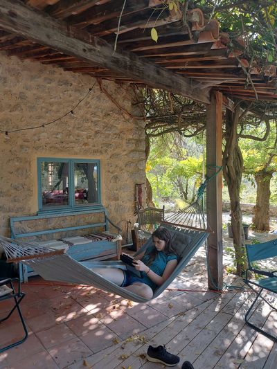 meisje leest boek in hangmat op terras van een provence-huis