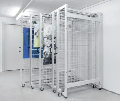 Mobile metal racks for storing artworks in a gallery.