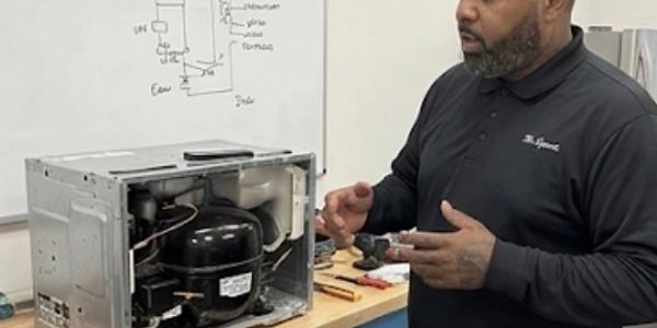 Man explaining an appliance's internal components.