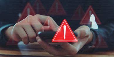 Person using smartphone with multiple red warning signs floating over the screen.
