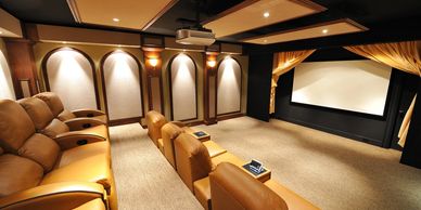 Luxury home theater with plush leather seating and a large screen.