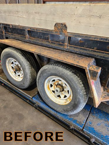 Rusty trailer wheels and fender before restoration.