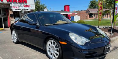 a black color car outside a car wash shop